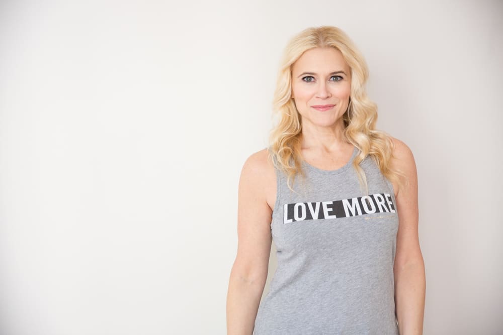 SheBrand founder and branding coach, Liz Dennery Sanders wears a shirt with text encouraging businesses and brands to love more